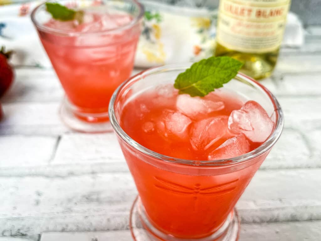 Horizontal shot of 2 glasses of Strawberry-Lillet Crush cocktails.