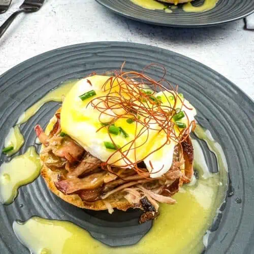 Pulled Pork Eggs Benedict on a plate with hollandaise sauce.