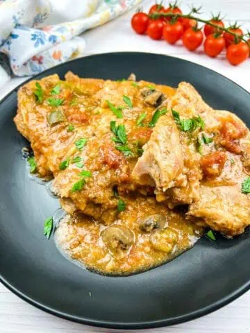 Slow Cooker Swiss Pork Chops on a black plate.