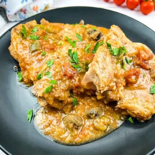 Slow Cooker Swiss Pork Chops on a black plate.