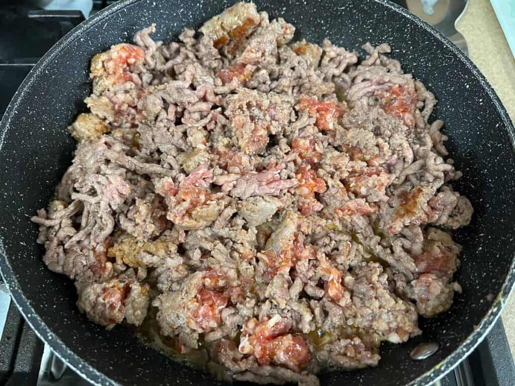 A frying pan filled with ground beef.