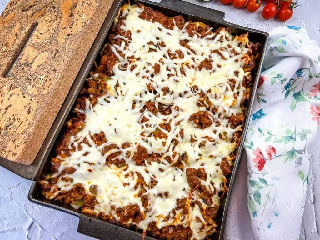 A casserole dish with meat, cheese and tomatoes.