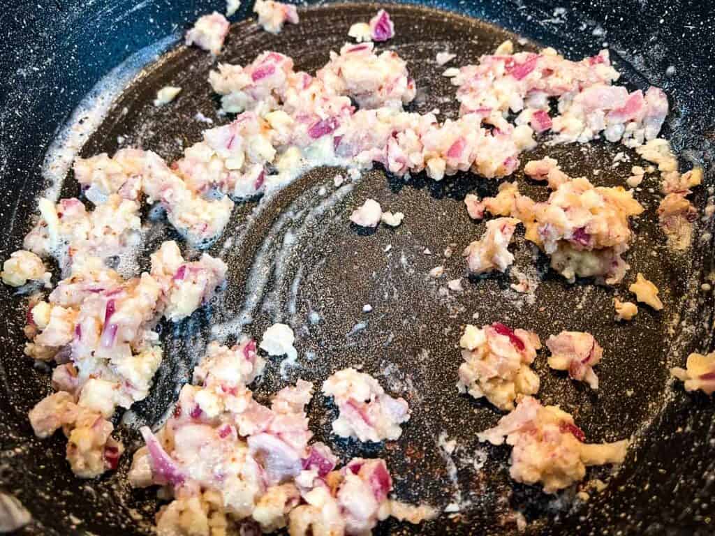 Flour added to cooked bacon in a skillet.