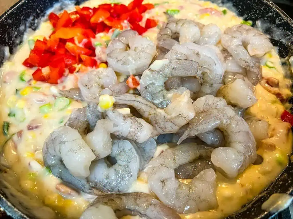 Shrimp, corn, and peppers in a skillet.