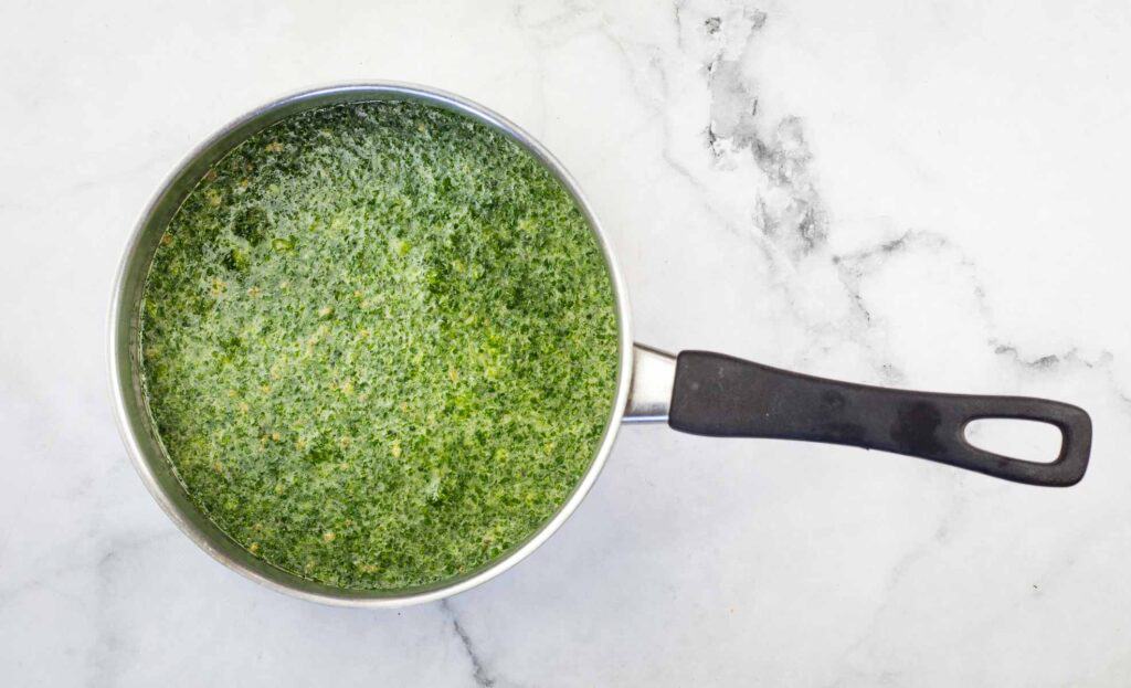 Rice and herb puree in a pan on a marble countertop.