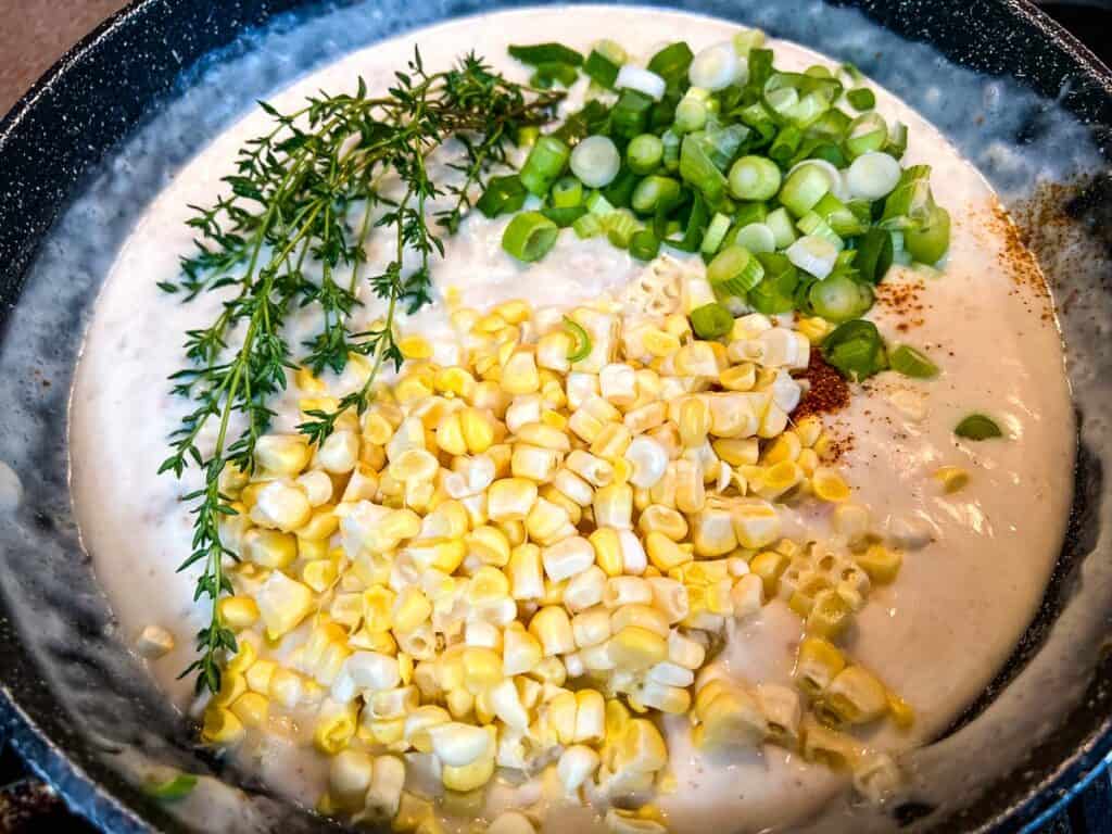 Corn and veggies added to the sauce in the skillet.