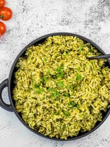 Green Rice in a Black Pan with Tomatoes and herbs.