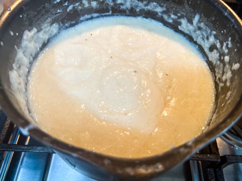 A pot filled with grits on top of a stove.