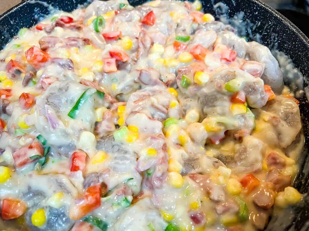 A frying pan filled with shrimp and vegetables.