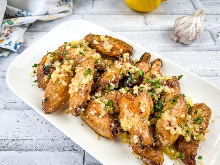 Chicken Wings with Garlic and Lemon on a White Plate.