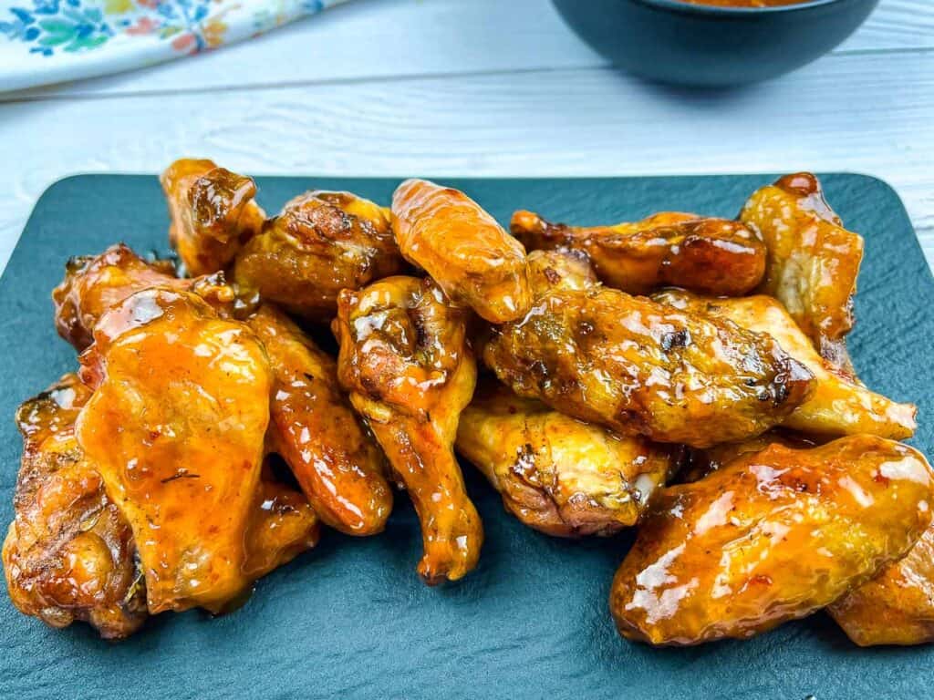 Smoked Peach-Chipotle Chicken Wings on a plate with sauce.