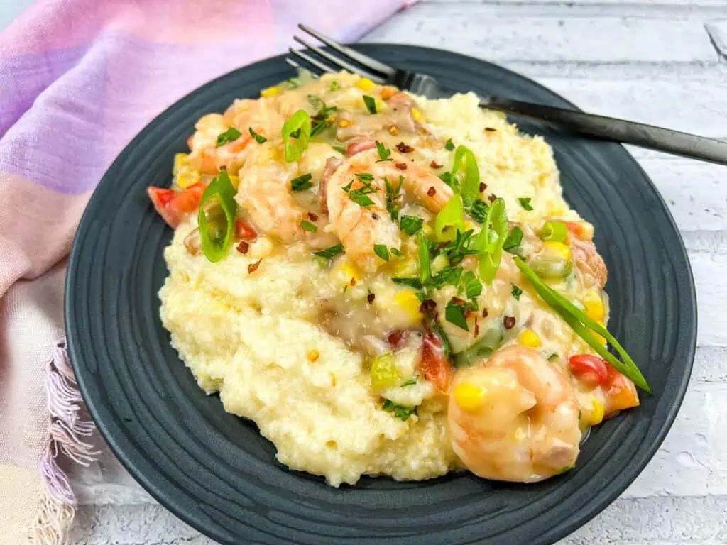 Shrimp and grits on a plate with a fork.