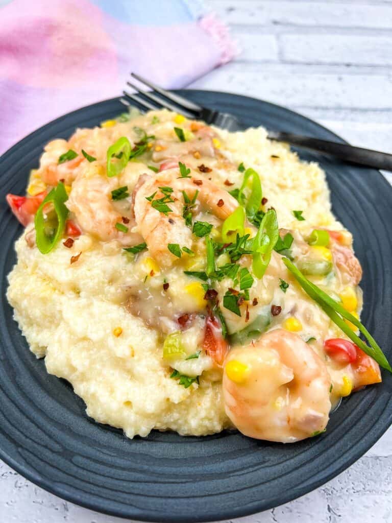 Shrimp and grits on a plate with a fork.