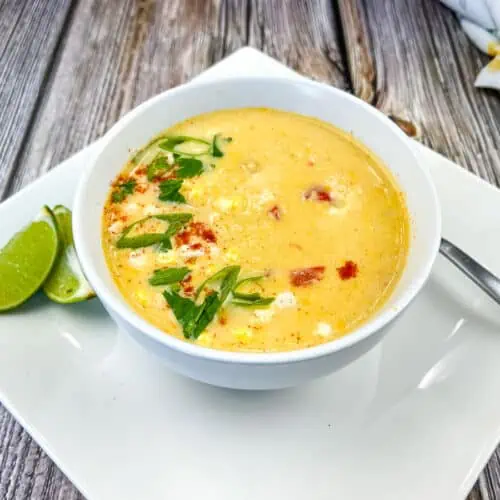 A bowl of soup on a white plate.