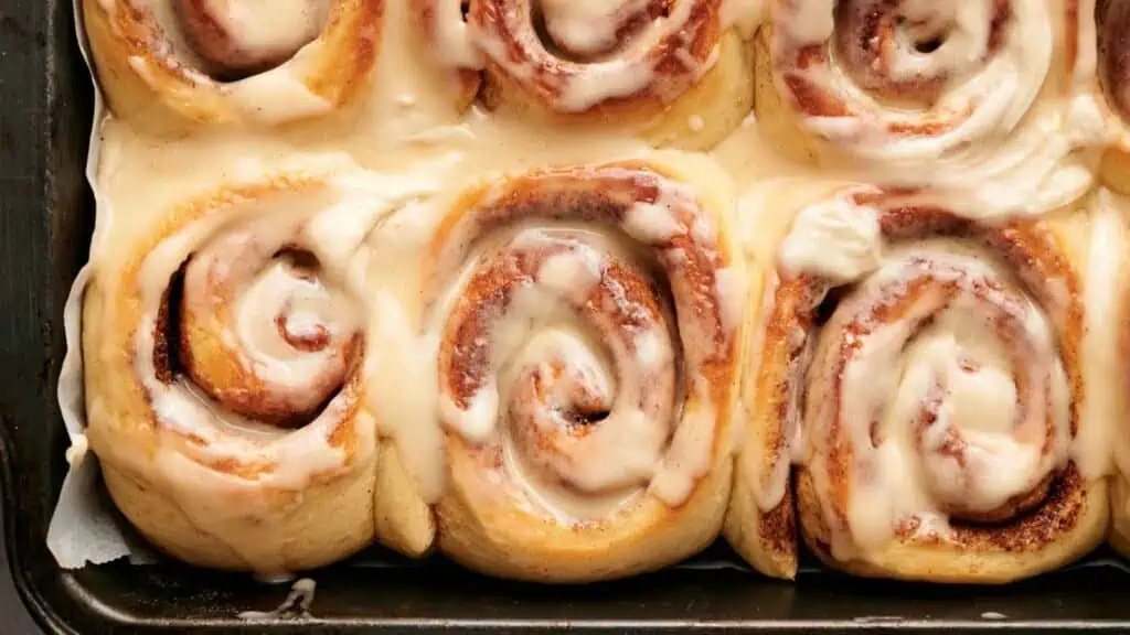 Cinnamon rolls in a pan with icing.