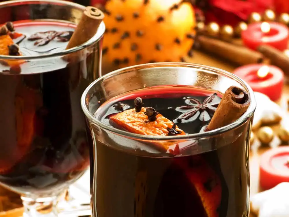 Two glasses of mulled wine with cinnamon sticks.