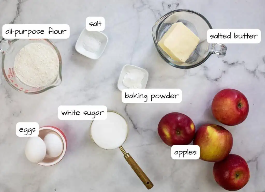 Ingredients for apple pie on a marble table.