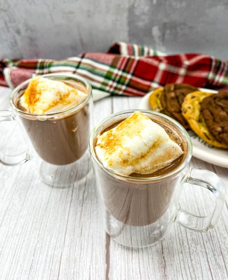 Two glasses of hot chocolate with marshmallows on top.