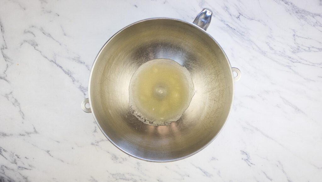 A wok filled with oil on a marble countertop.