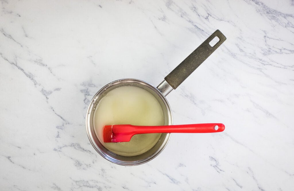 A pan with a red spatula in it.