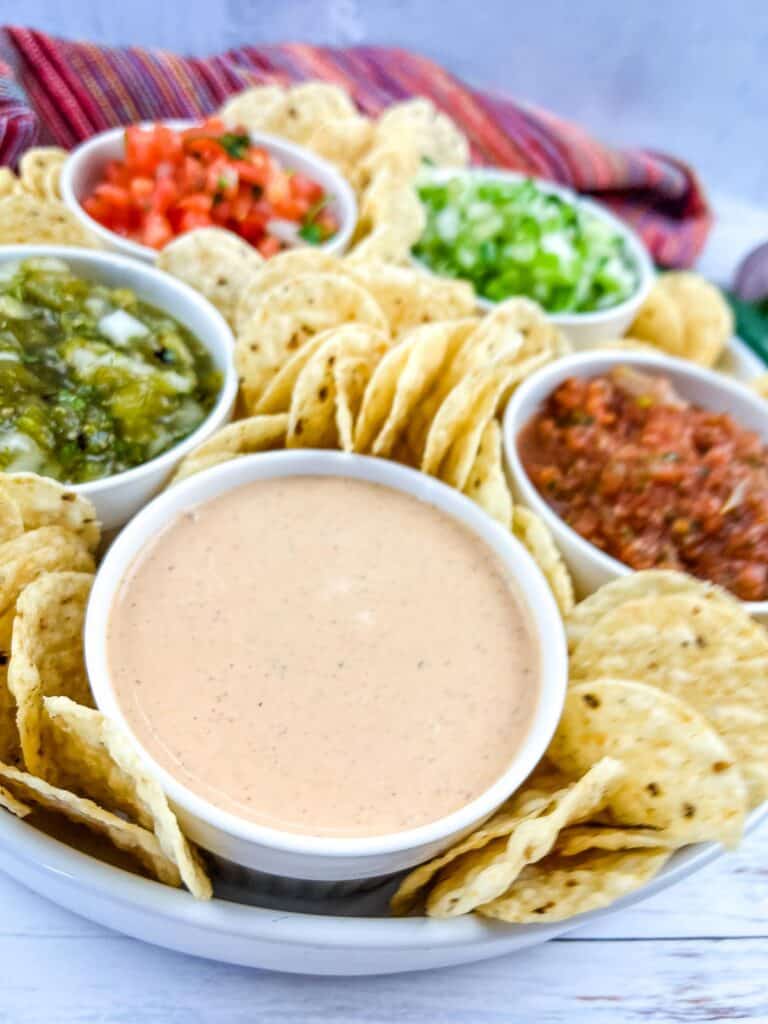 Mexican dips and chips on a white plate.