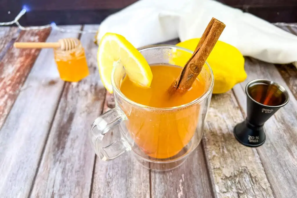 A cup of hot toddy with lemon and cinnamon.