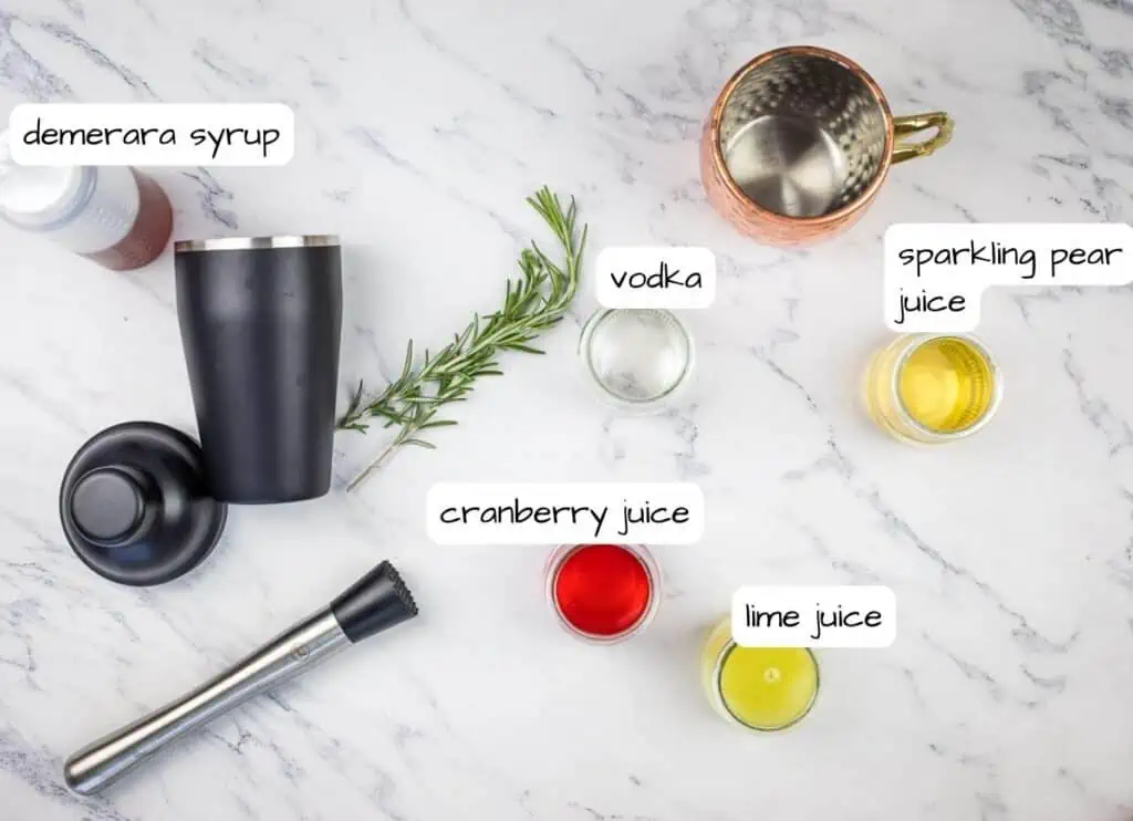 The ingredients for a cocktail are laid out on a marble table.