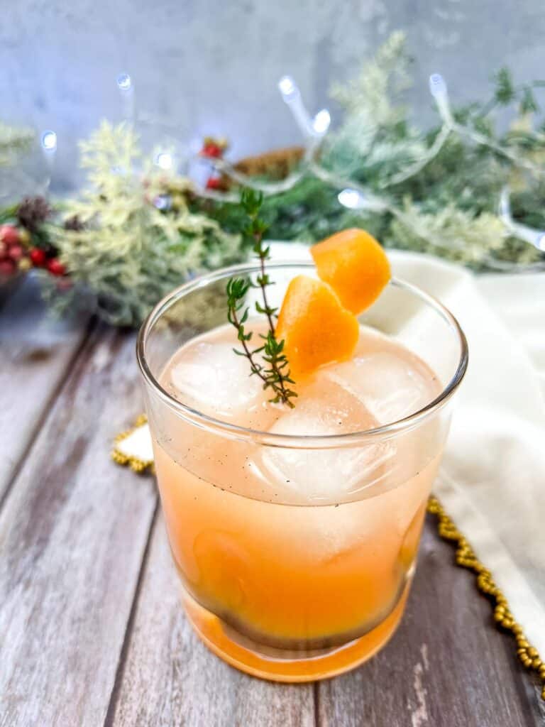 A Vanilla & Thyme Paloma garnished with sprigs of thyme.