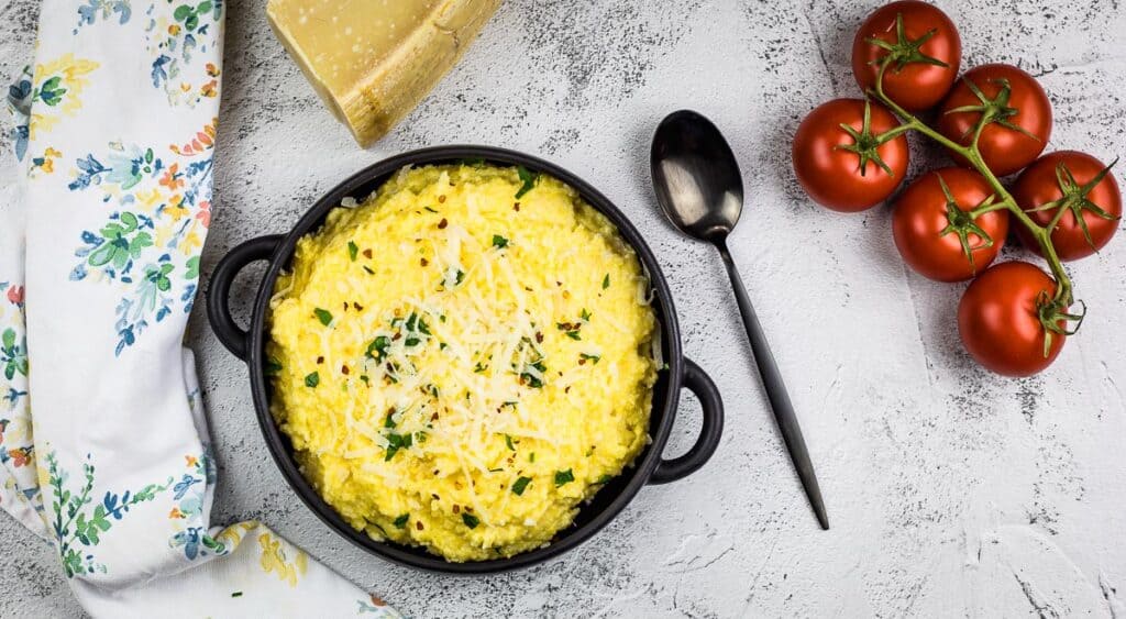 Polenta in a bowl with tomatoes and herbs.