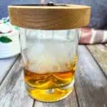 A glass of whiskey with a candle in it.