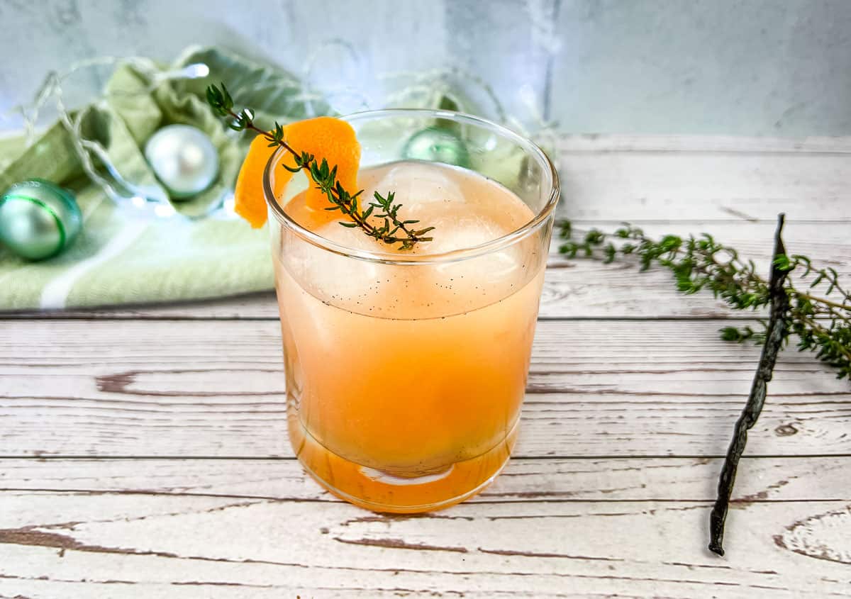 An  winter vanilla thyme vanilla paloma mocktailwith a sprig of thyme.