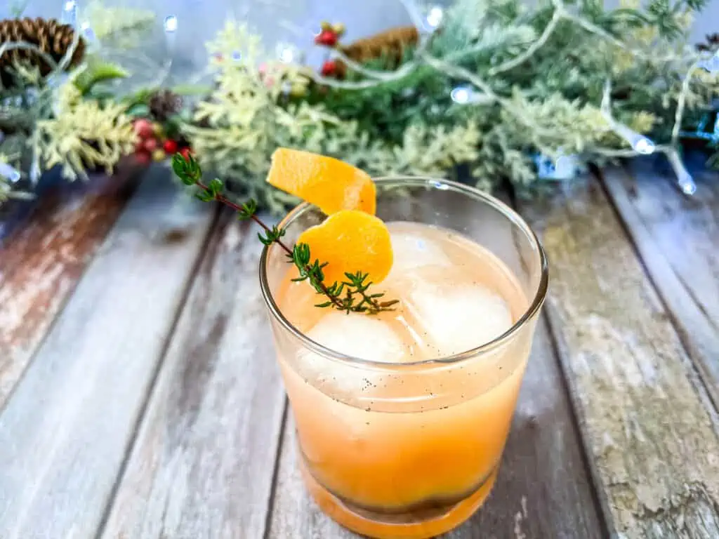 A Vanilla & Thyme Paloma garnished with sprigs of thyme.