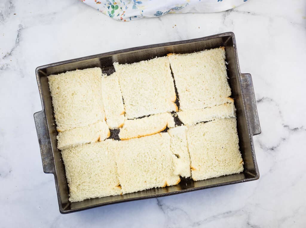 A metal pan with sliced bread in it.