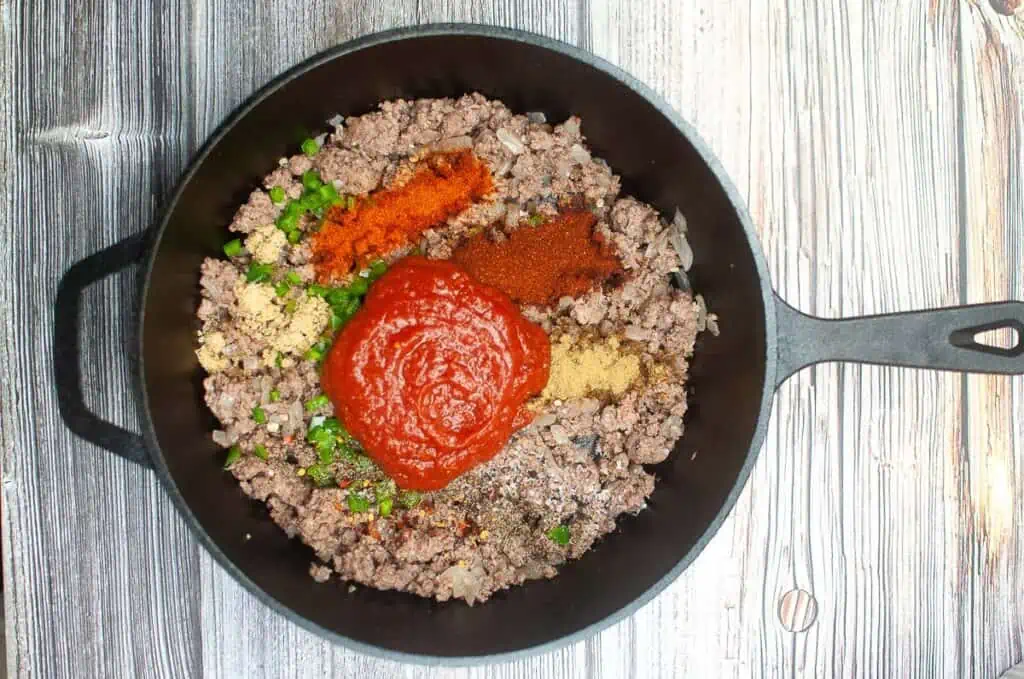 A skillet filled with ground beef and sauce.
