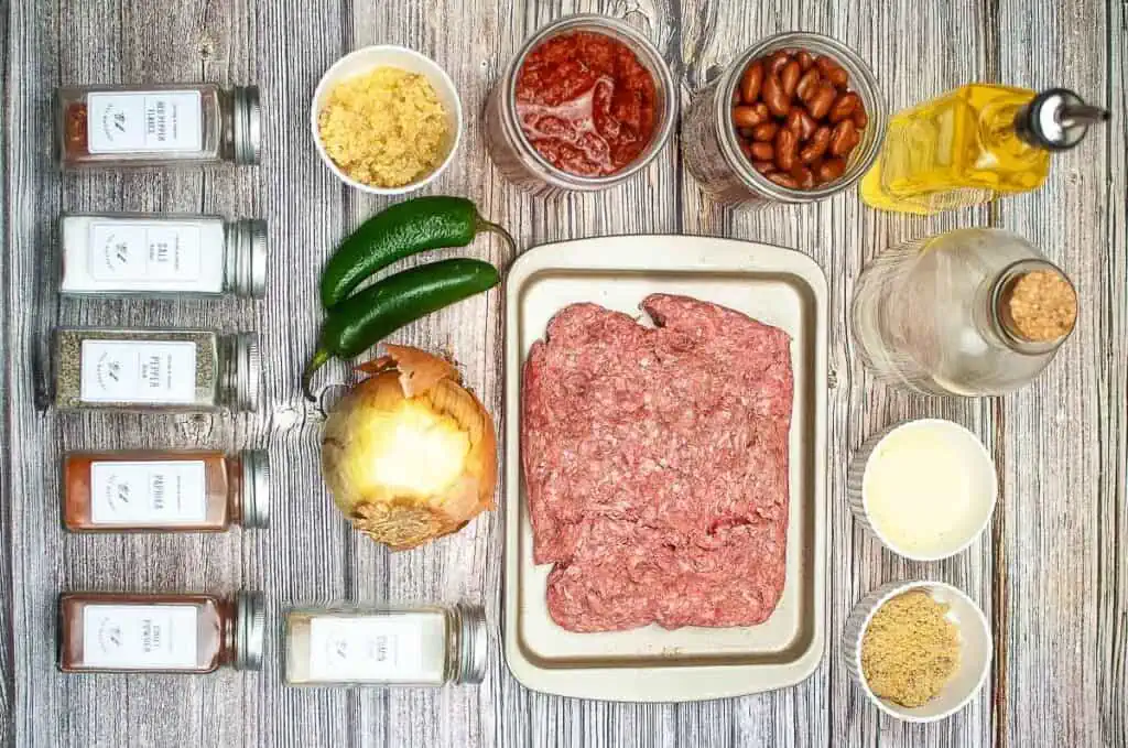 The ingredients for a meatloaf are laid out on a wooden table.