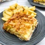 A slice of Cubano Sandwich Casserole on a plate with potato chips.