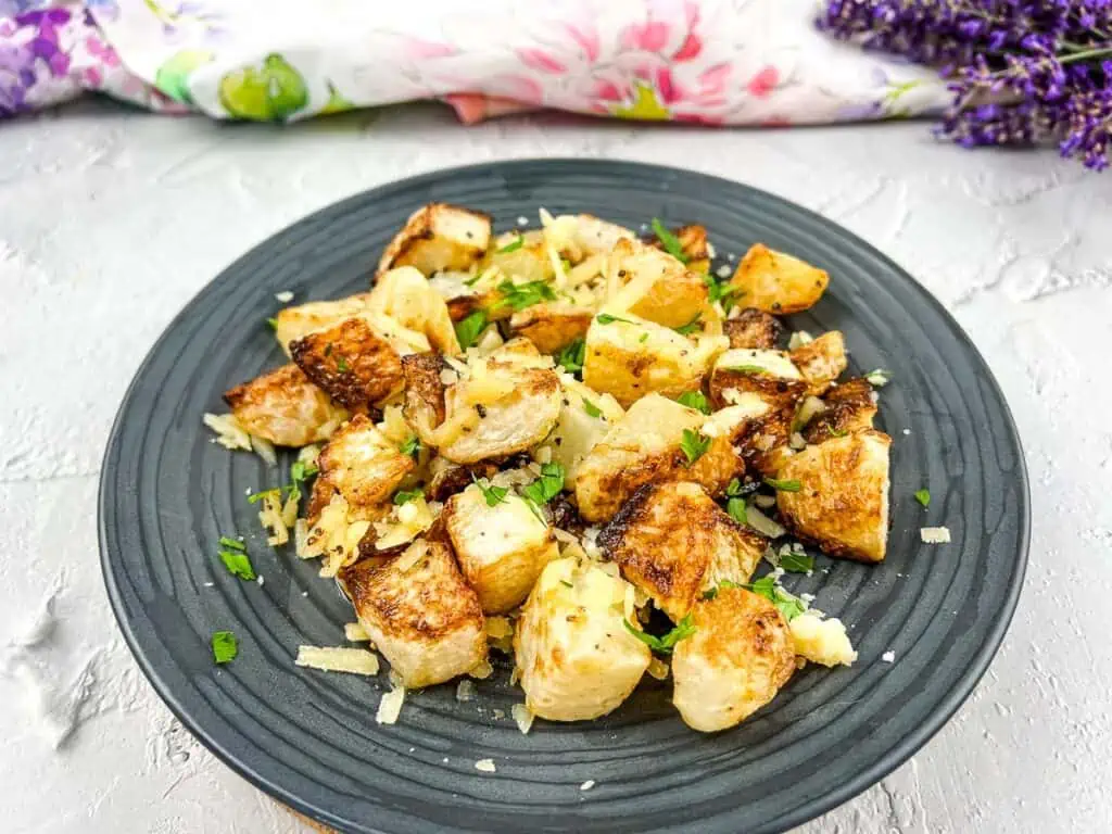 Roasted potatoes on a plate with parmesan cheese.