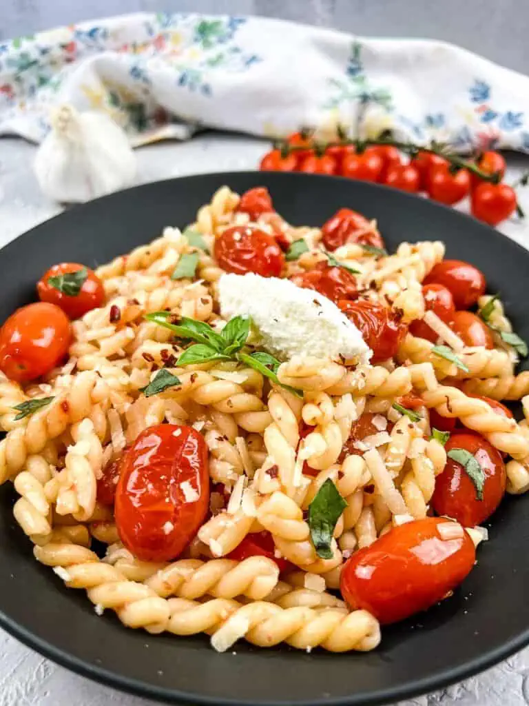 A plate of pasta with tomatoes and basil.