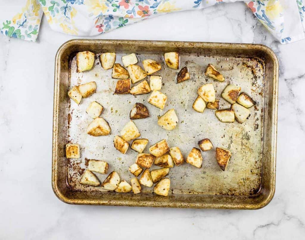 Cubed roasted kohlrabi on a baking sheet.