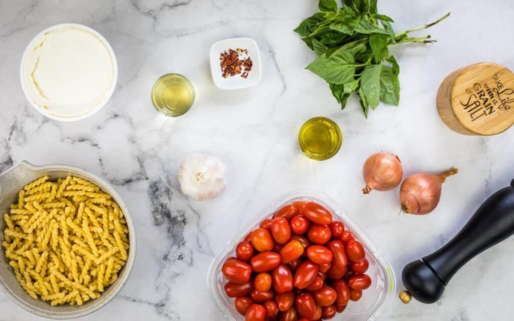 Ingredients for a pasta dish with tomatoes and basil.