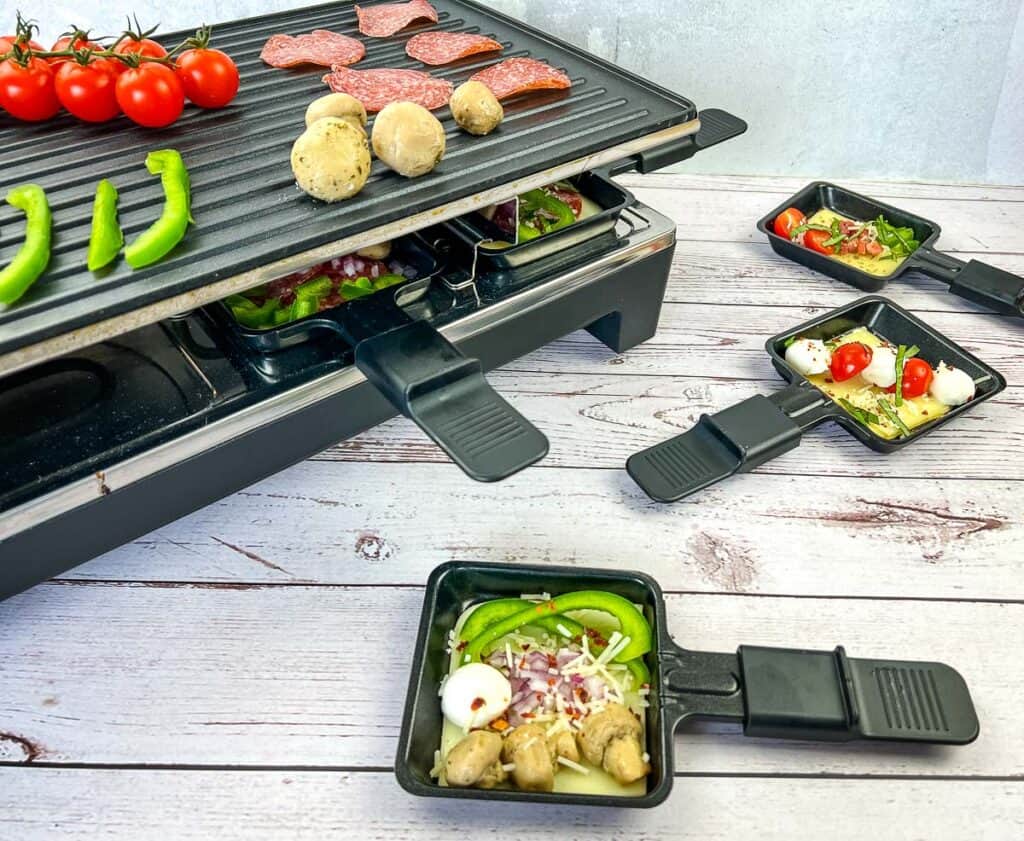 A griddle with vegetables and meat on it.