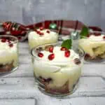 Pomegranate trifle in glasses with whipped cream and pomegranate.