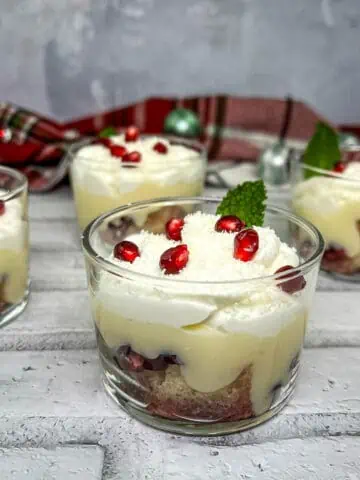 Pomegranate trifle in glasses with whipped cream and pomegranate.