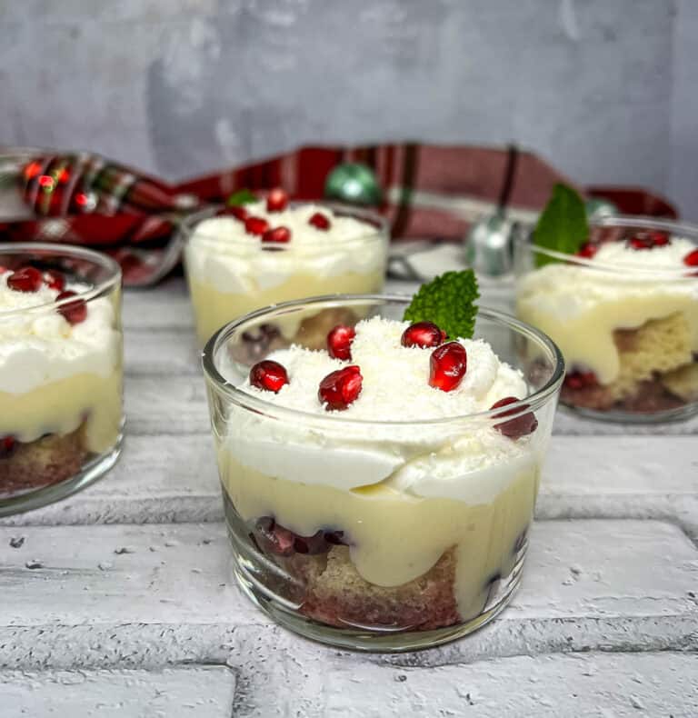 Pomegranate trifle in glasses with whipped cream and pomegranate.