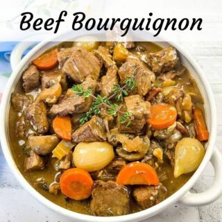 Beef bourguignon in a white bowl.