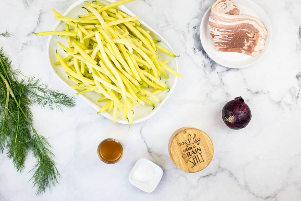 Ingredients to make German Yellow Beans on a marble counter.