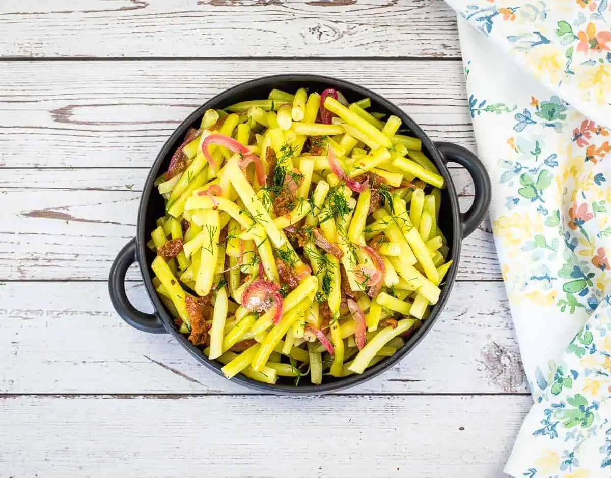 A bowl of German yellow beans on a wooden table.