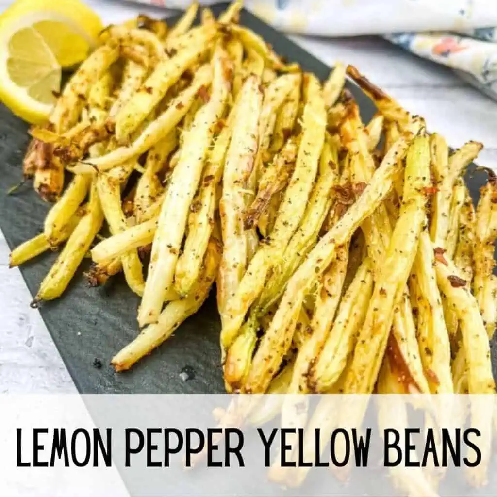Lemon pepper yellow beans on a black plate.