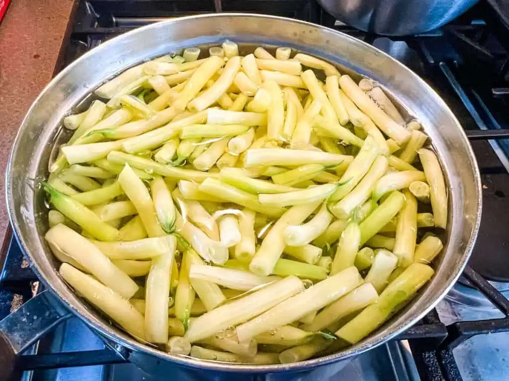 A pot full of yellow beans on a stove top.