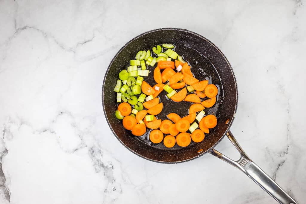 Carrots and celery in a frying pan.